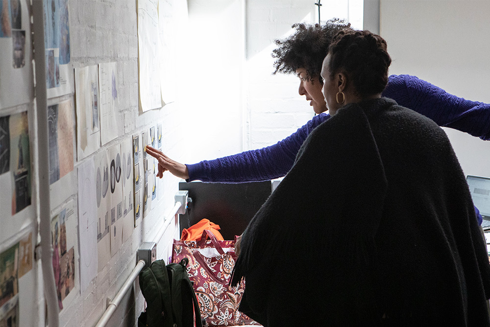 Creatives from the STARS team point to pinned images on a noticeboard