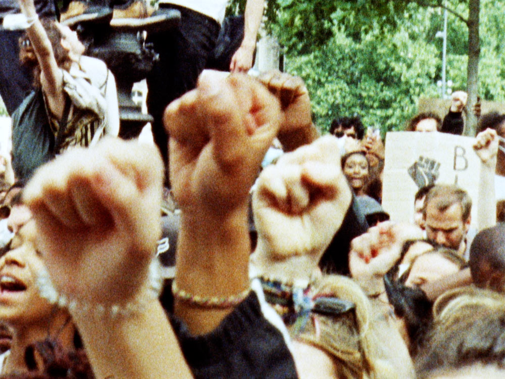 Fists raised in protest against a crowd for Black power