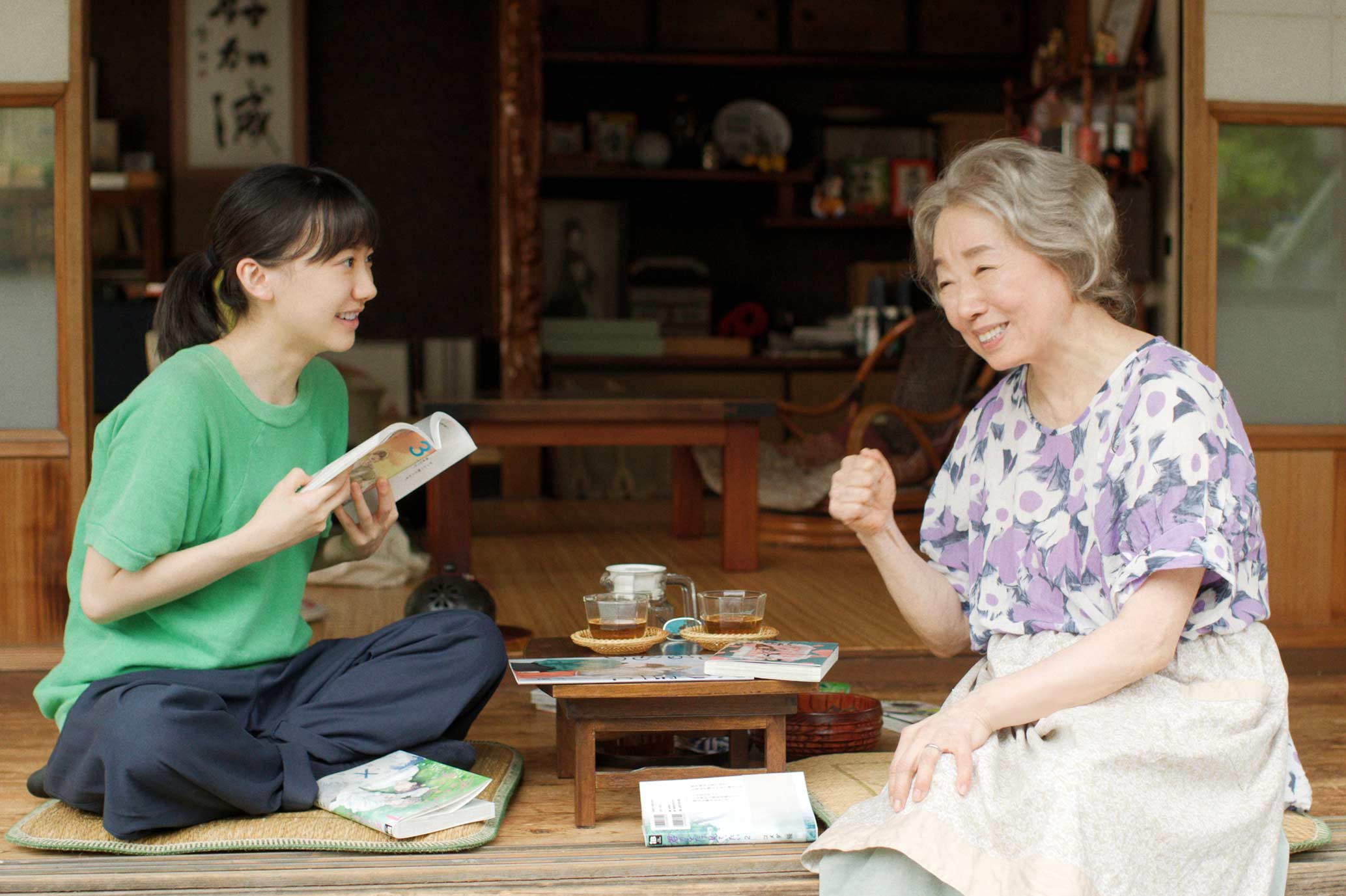 A young women and an older woman share tea and manga