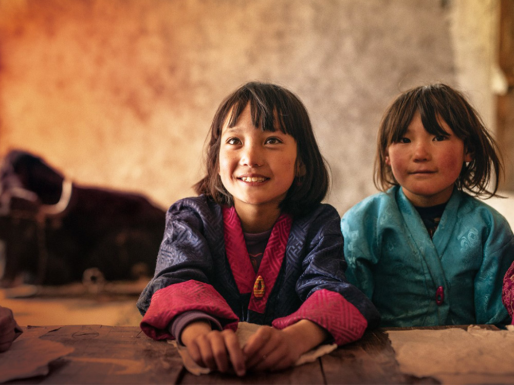 Two young people in Bhutan stare at the camera, happy but also curious