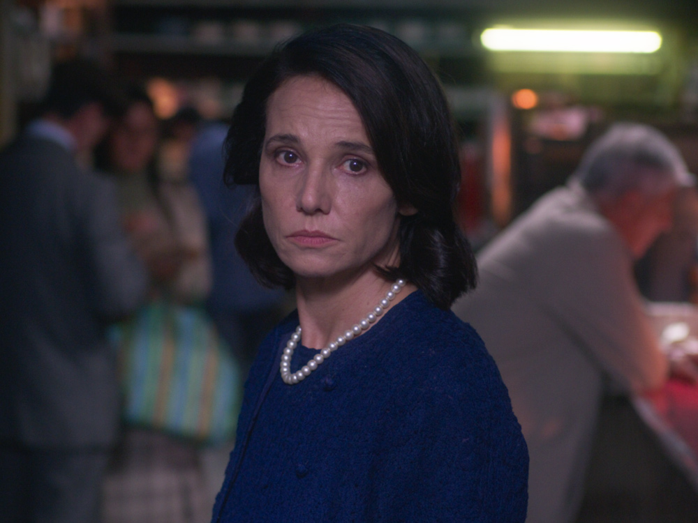 A well-off woman looks concerned in a bar