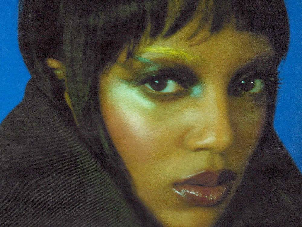 A close up of Liv.e's face, against a blue background