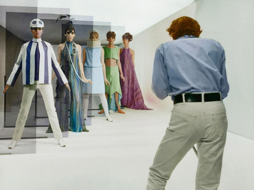 A person turning away from the camera to look at 5 mannequins lined up