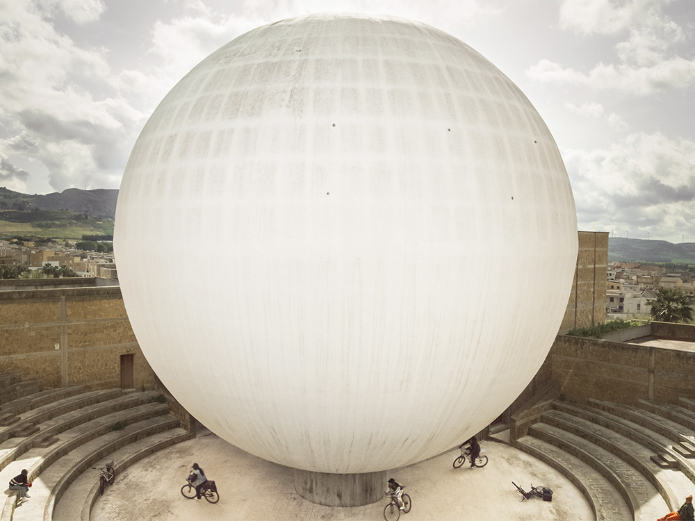 A huge white org sits on top of a circular skate park