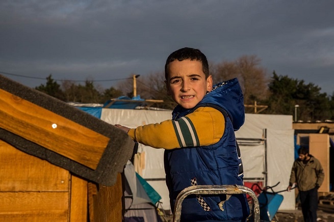 A young Kurdish boy helping The Connor Brothers to build a shelter in the Calais Jungle. Photograph: Vianney LeCaer